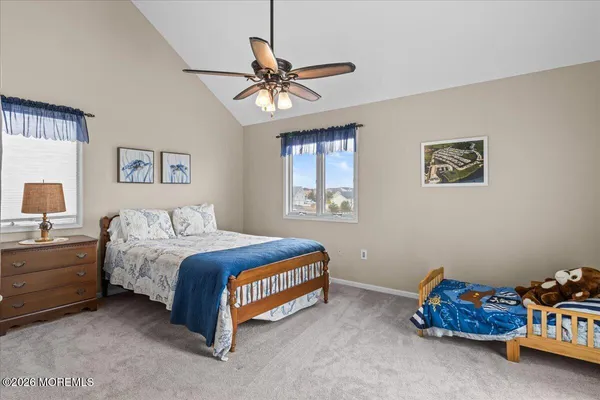 a bedroom with a bed and a lamp on dresser