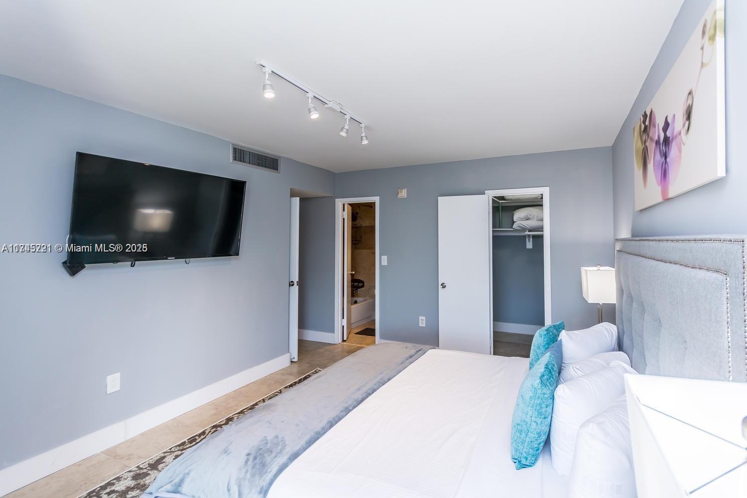 17620 Atlantic Boulevard, Unit 519 Sunny Isles Beach, FL 33160 - Photo 12 of 33 a bedroom with a bed and a flat screen tv