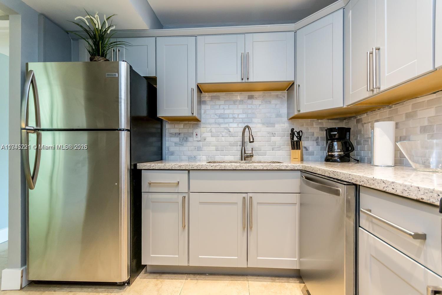17620 Atlantic Boulevard, Unit 519 Sunny Isles Beach, FL 33160 - Photo 21 of 33 a kitchen with stainless steel appliances white cabinets and a refrigerator