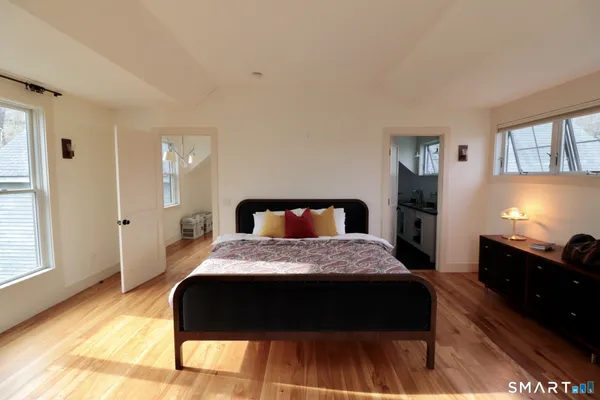 a bedroom with a bed and wooden floor