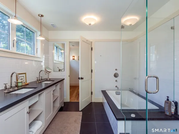 a en suite bathroom with a granite countertop sink and a mirror