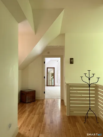 a view of a hallway with wooden floor and chair