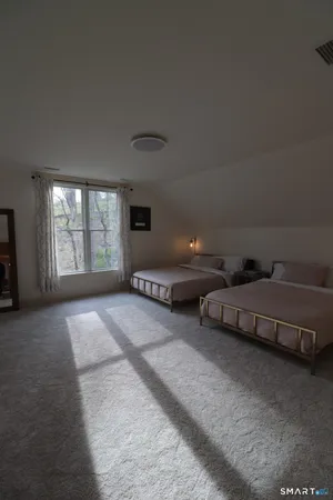 a spacious bedroom with two beds and a window