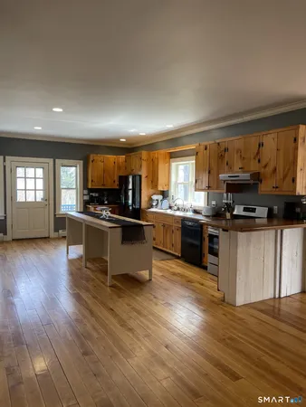 a kitchen with stainless steel appliances kitchen island granite countertop a stove a sink and a microwave