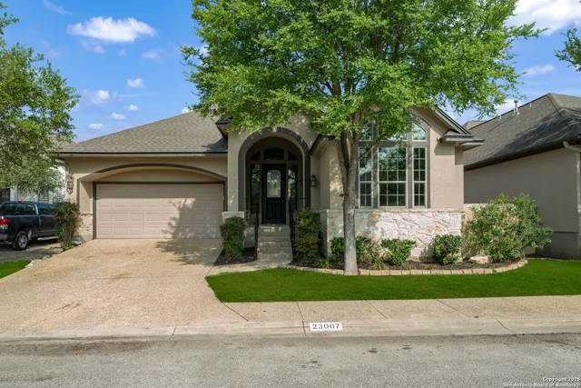 a front view of a house with a yard and potted plants