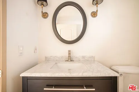 a bathroom with a sink a toilet and a mirror