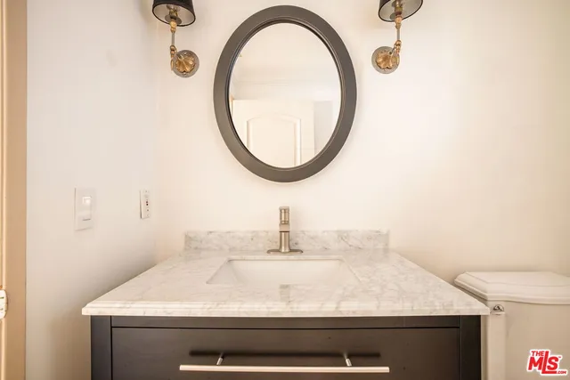 a bathroom with a sink a toilet and a mirror