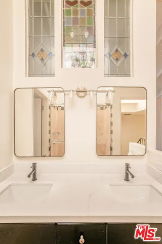 a bathroom with a sink and a mirror with shower