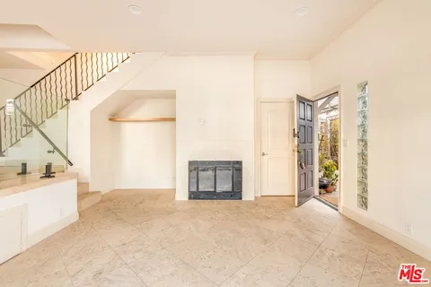 a view of an empty room with stairs and a window