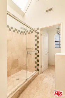 a bathroom with a granite countertop sink a mirror and shower