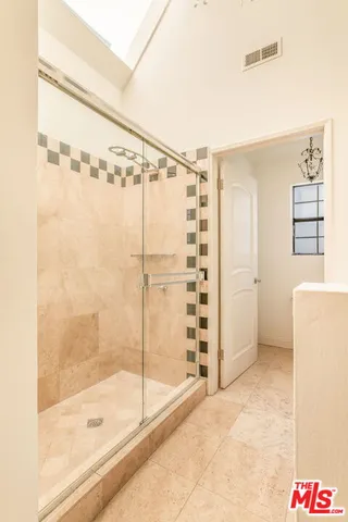 a bathroom with a granite countertop sink a mirror and shower