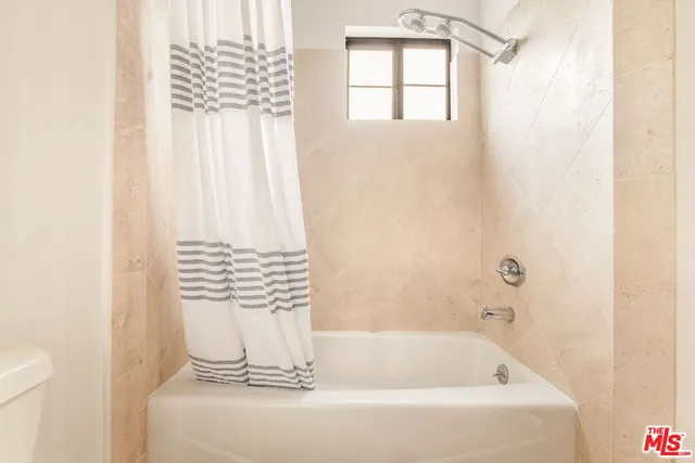 a view of a house with potted plants next to a road