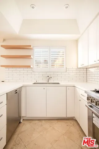 a kitchen with granite countertop a sink and a stove