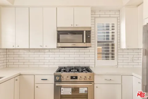 a kitchen with granite countertop cabinets stainless steel appliances and a sink