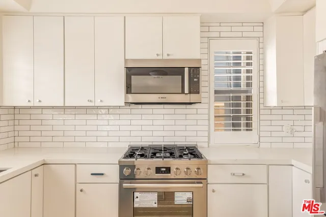 a kitchen with granite countertop cabinets stainless steel appliances and a sink