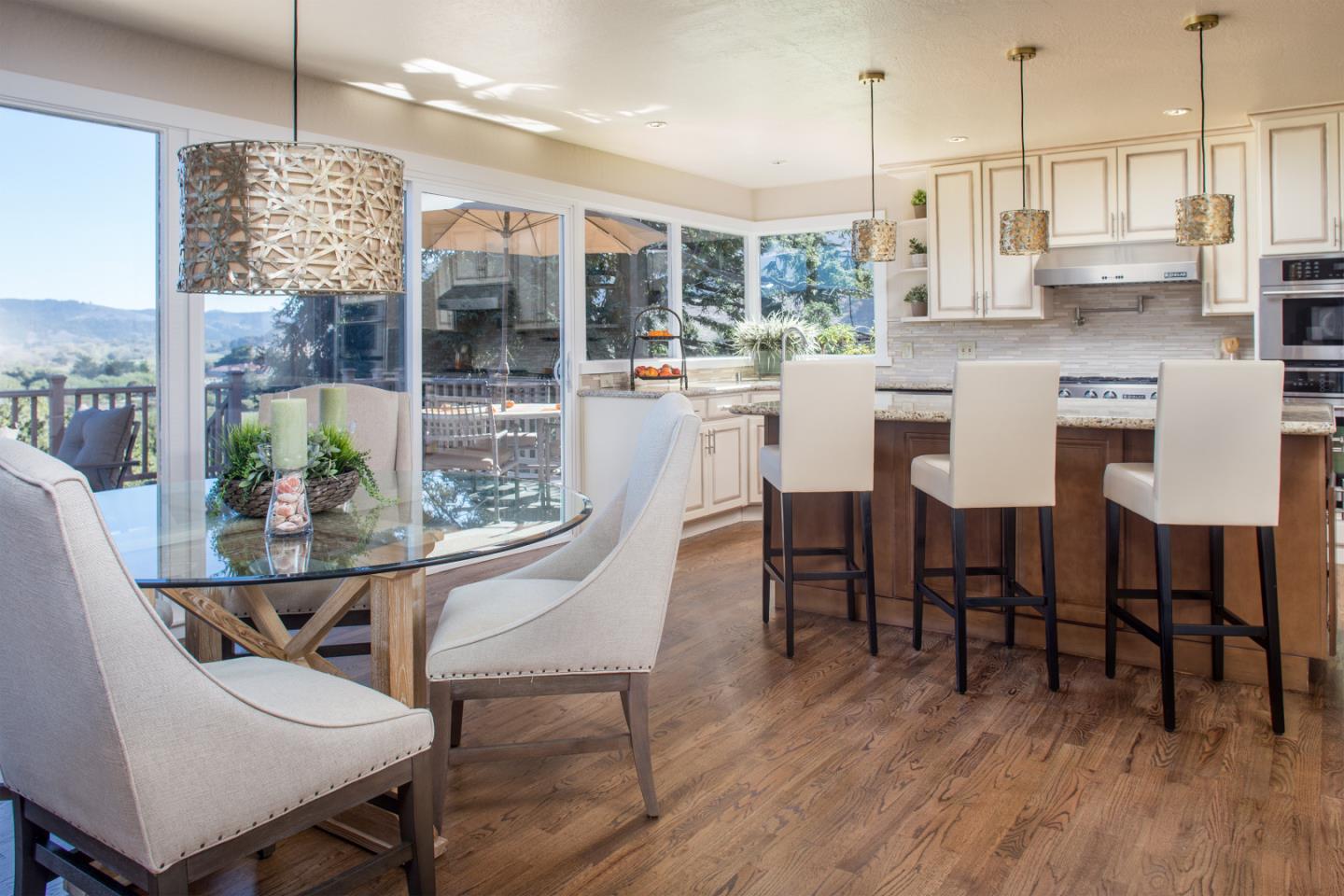 2925 Ribera Road Carmel, CA 93923 - Photo 8 of 27 a kitchen with stainless steel appliances granite countertop a table chairs and a wooden floor
