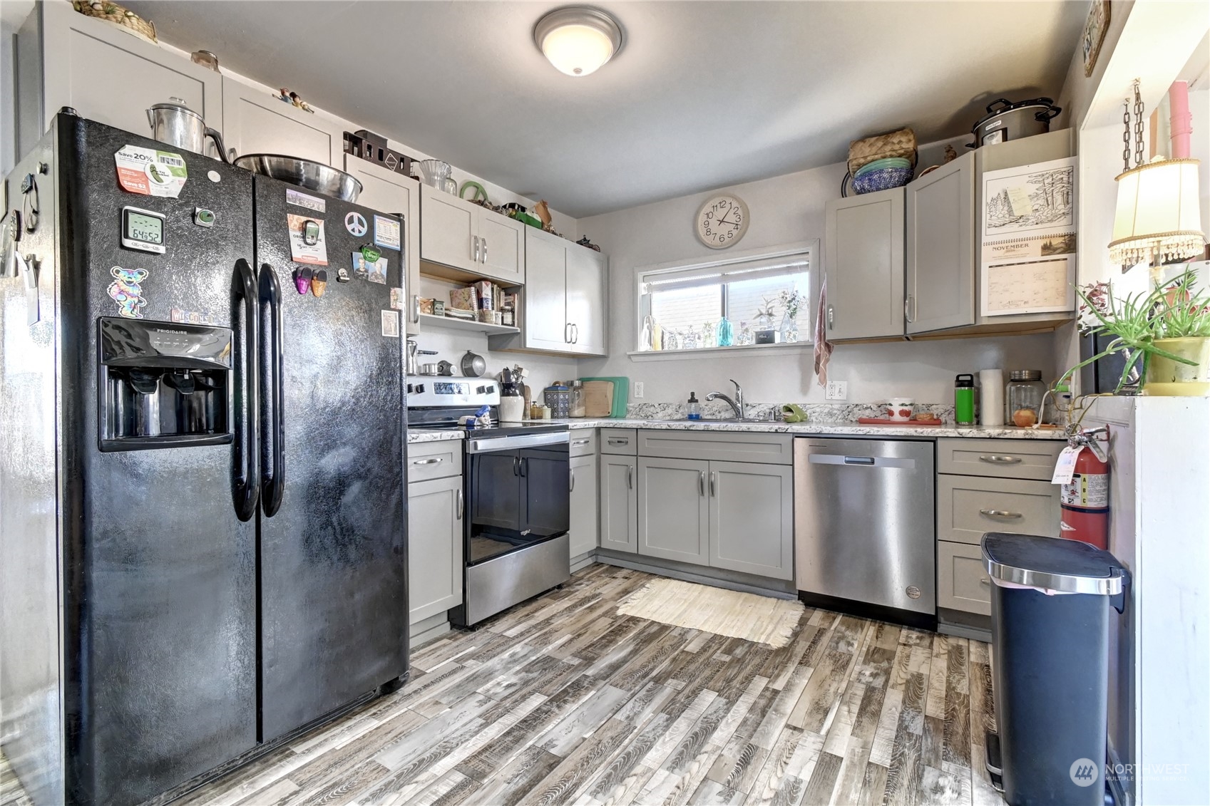 2223 Rockefeller Avenue Everett, WA 98201 - Photo 6 of 21 a kitchen with stainless steel appliances granite countertop a refrigerator a sink dishwasher a stove with wooden cabinets and floor