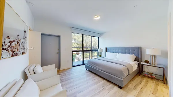 a bedroom with a bed and a large window