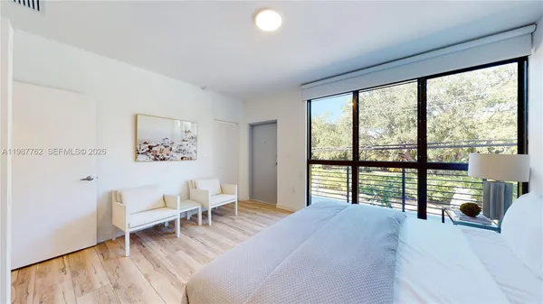 a bedroom with a bed and a large window