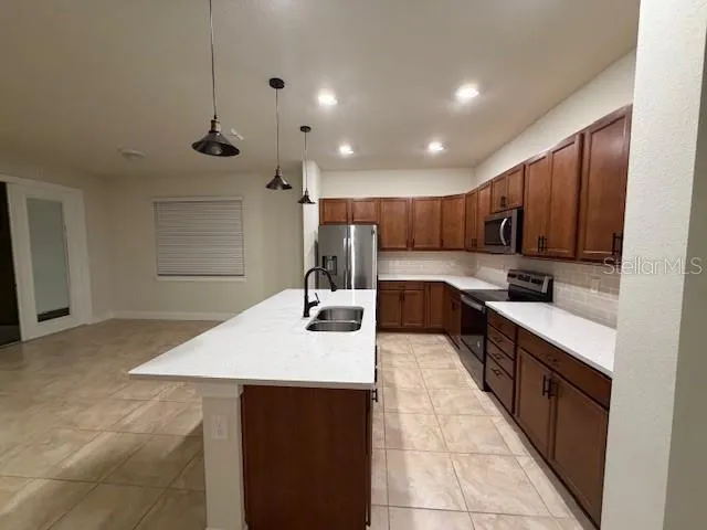 a large kitchen with kitchen island a sink a stove and refrigerator