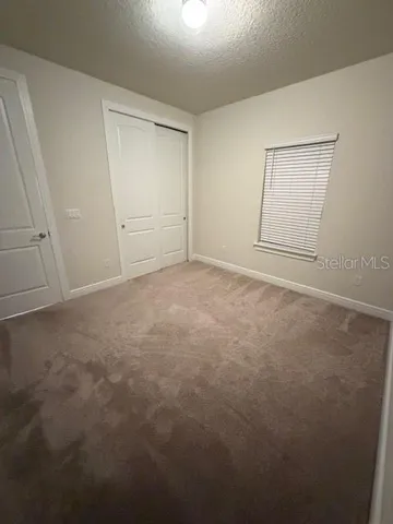 an empty room with windows and closet