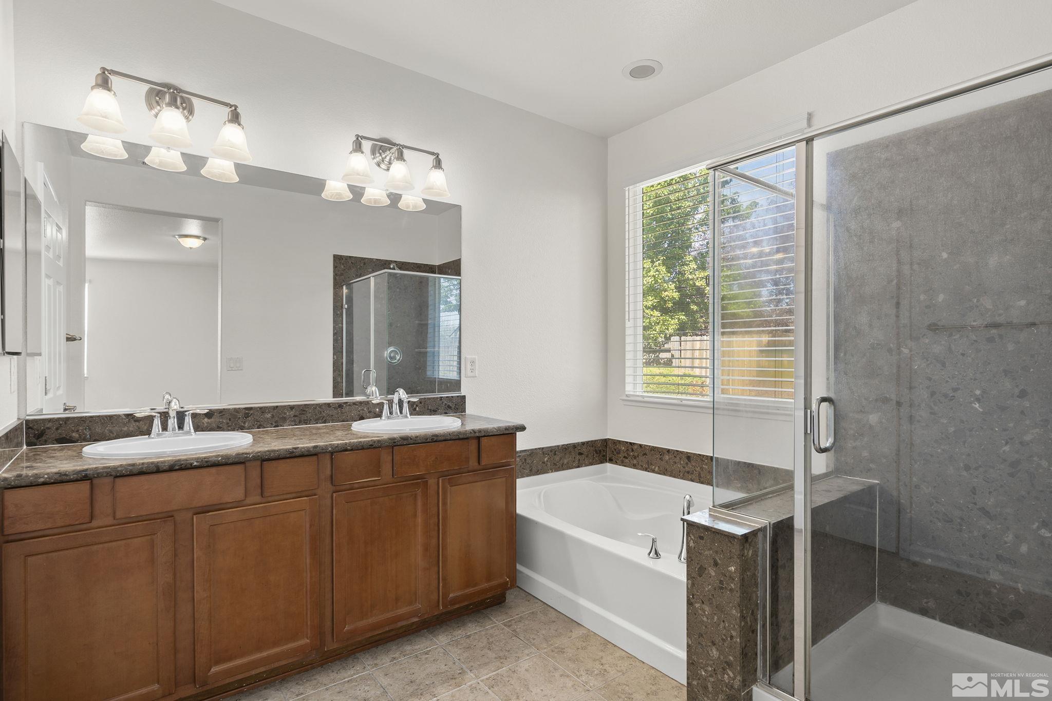 9130 Andraste Way Reno, NV 89506 - Photo 13 of 19 a bathroom with a tub a sink and mirror