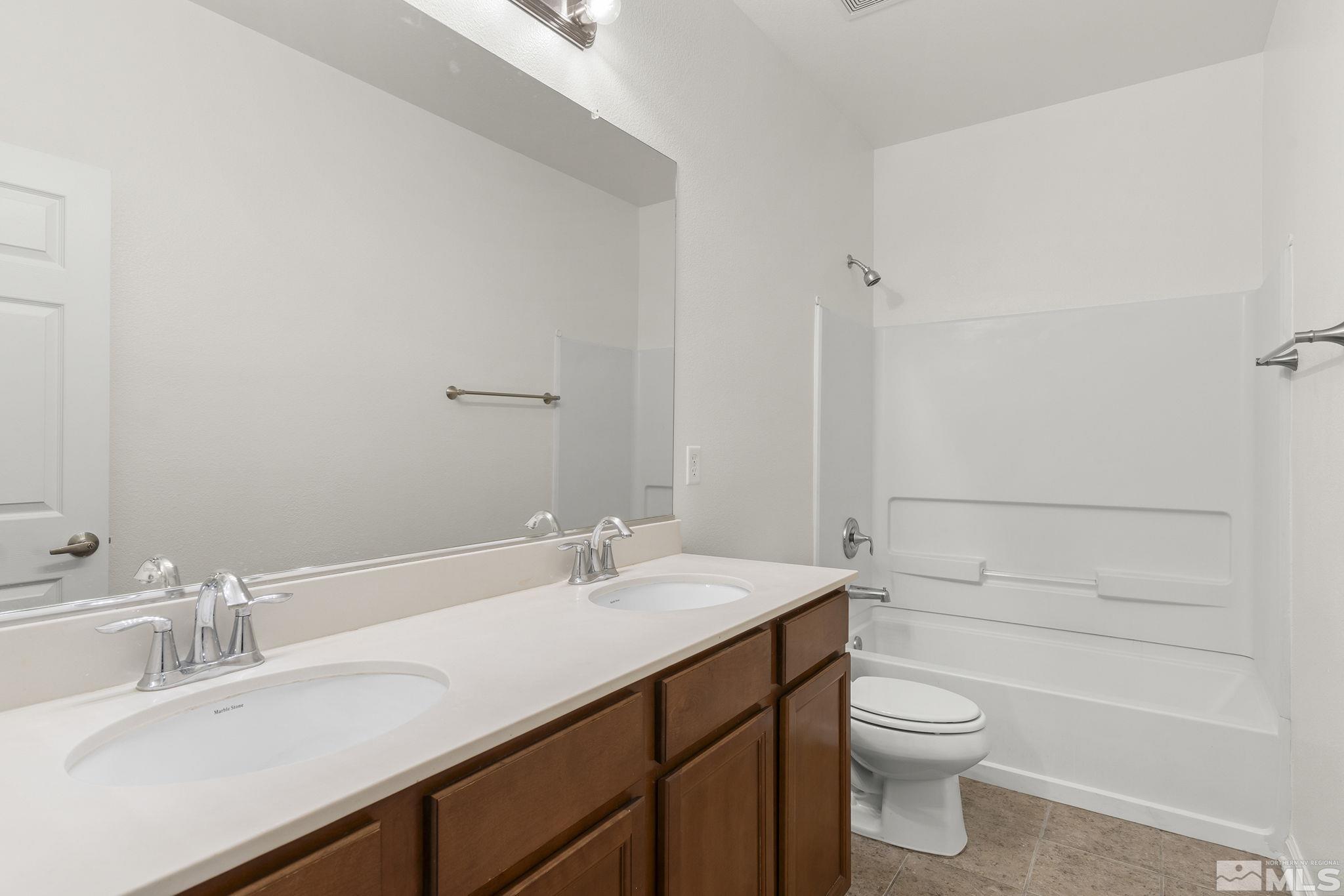 9130 Andraste Way Reno, NV 89506 - Photo 17 of 19 a bathroom with a sink a toilet and shower