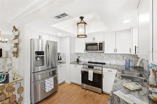 a kitchen with stainless steel appliances a stove a sink and a refrigerator