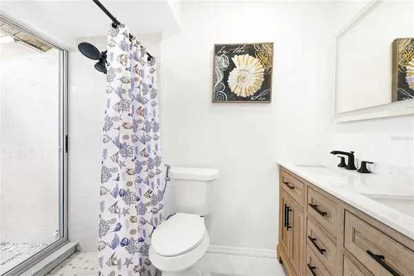 a bathroom with a granite countertop toilet sink and mirror