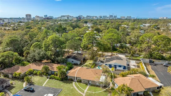 an aerial view of residential houses with outdoor space and trees