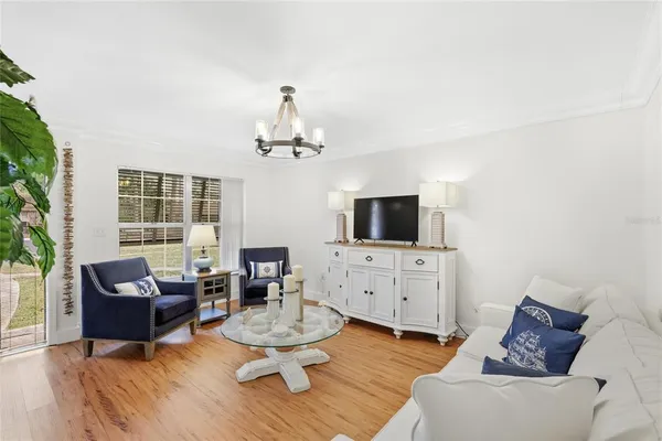 a living room with furniture flat screen tv and window