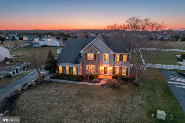 a view of a house with a yard next to a lake