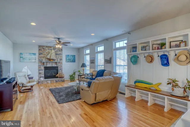 a living room with furniture floor to ceiling window and wooden floor