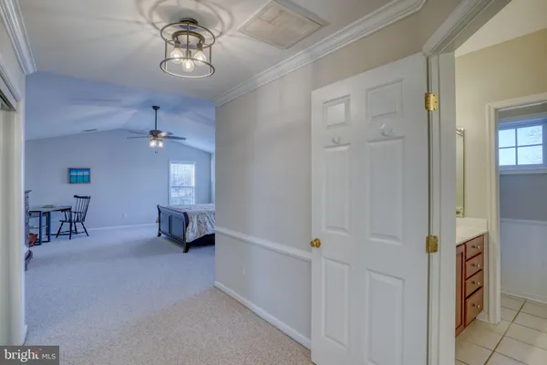 an empty room with chandelier fan and windows