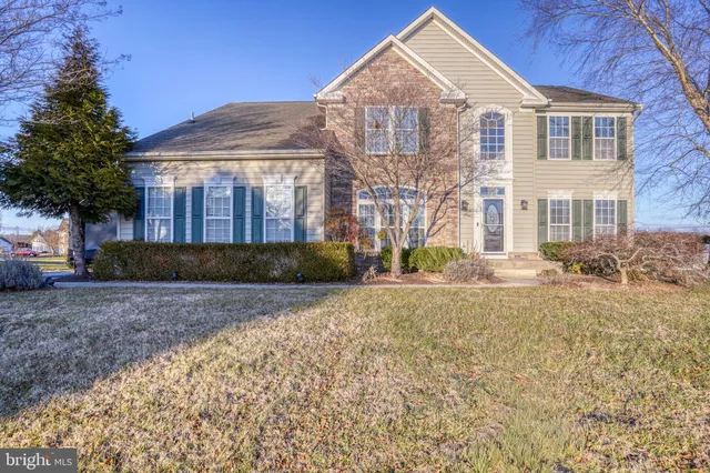 a front view of a house with a yard and a garage