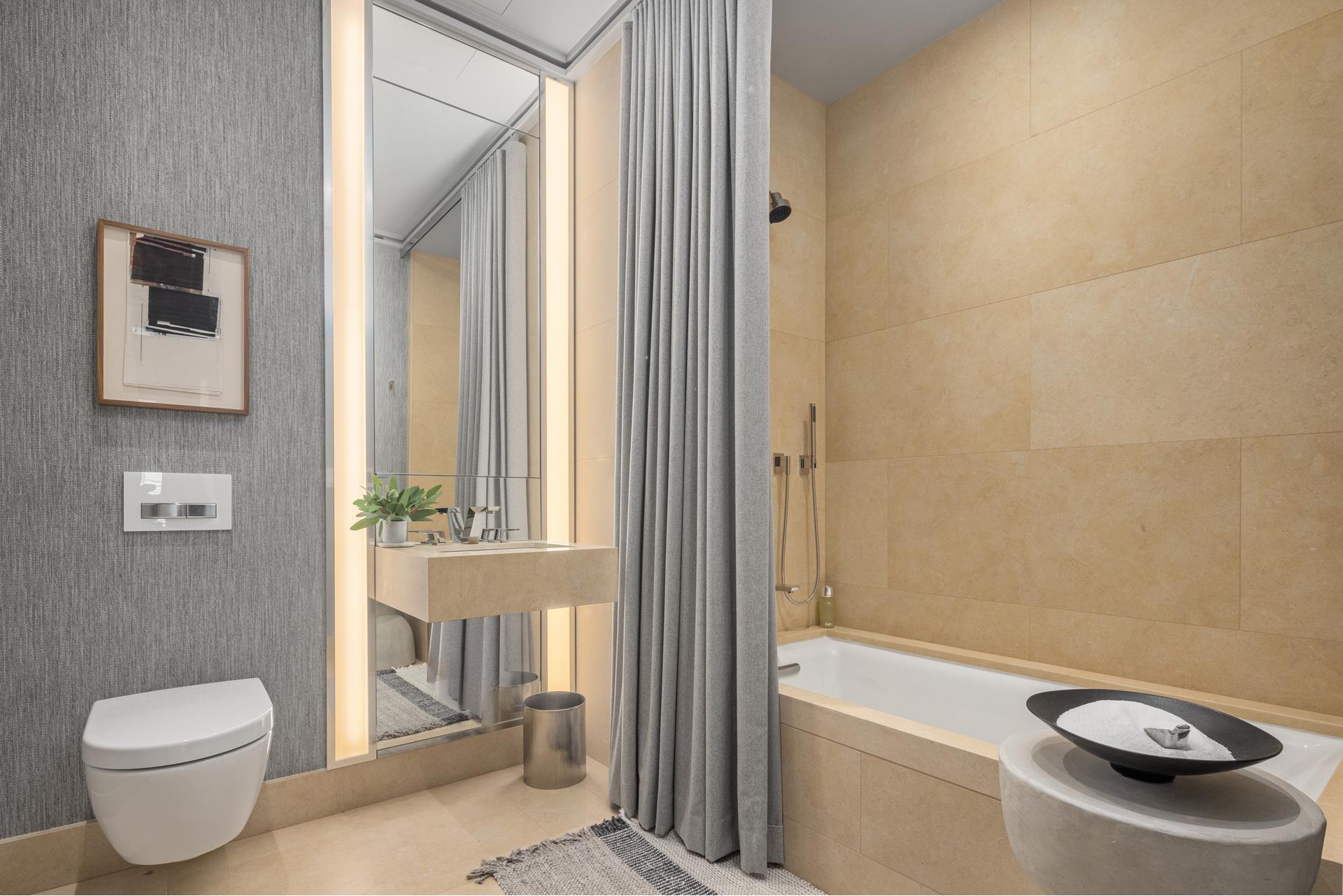 53 West 53rd Street, Unit 72B Manhattan, NY 10019 - Photo 10 of 39 a bathroom with a toilet a sink and a bathtub