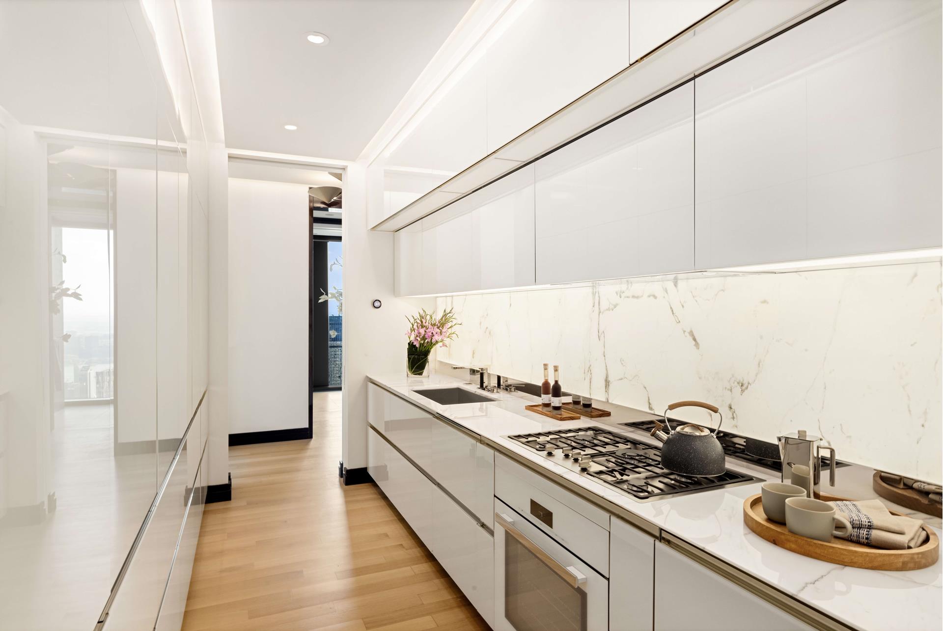53 West 53rd Street, Unit 72B Manhattan, NY 10019 - Photo 6 of 39 a kitchen with a sink stove and cabinets