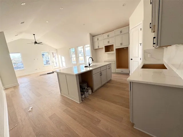 a large white kitchen with sink and refrigerator