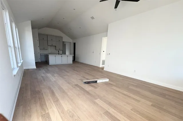 a view of empty room with wooden floor and window