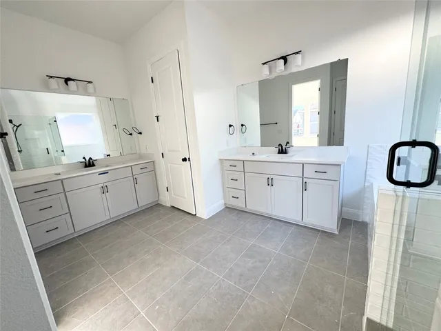 a spacious bathroom with a double vanity sink a mirror and a bathtub