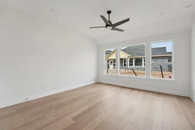 a view of a room with wooden floor and ceiling fan