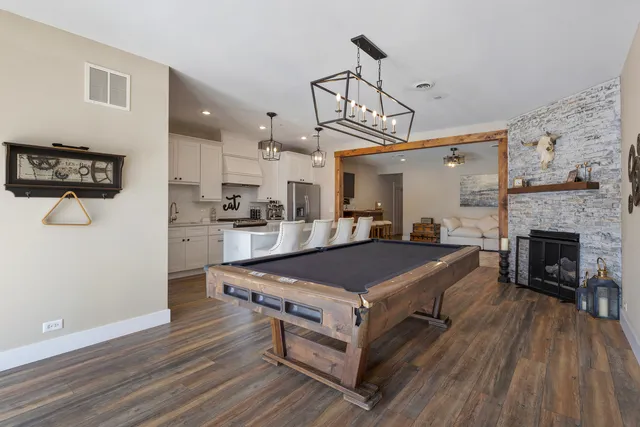 a living room with stainless steel appliances kitchen island granite countertop furniture and a fireplace