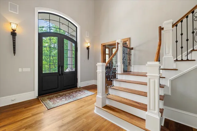 an aerial view of a house with a swimming pool and large trees