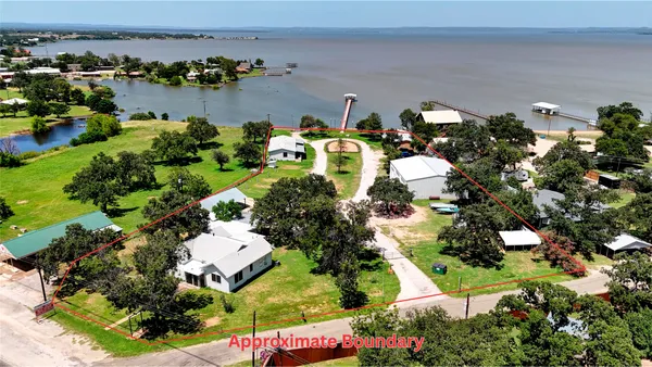 an aerial view of a house with a yard and lake view