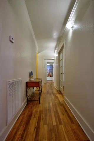 a view of a hallway with wooden floor and furniture