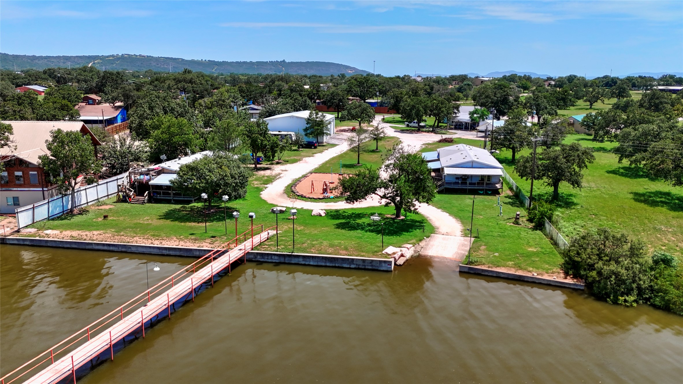 1504 Ranch Road 261 Buchanan Dam, TX 78609 - Photo 2 of 37 an aerial view of a house with a garden and lake view