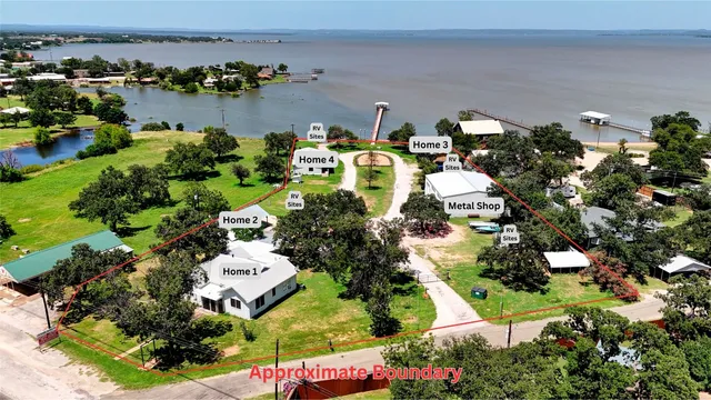 an aerial view of a house with a yard and lake view