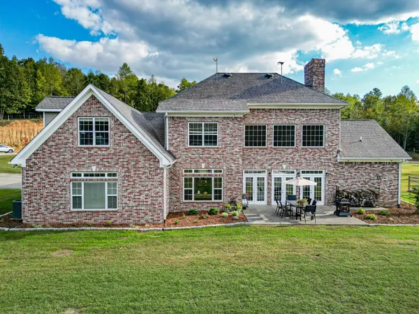 a view of a big house with a big yard and potted plants