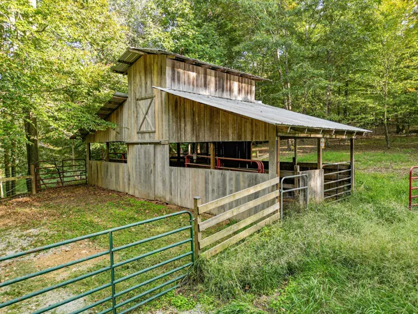 a view of a hallway with wooden floor and a livingroom with furniture