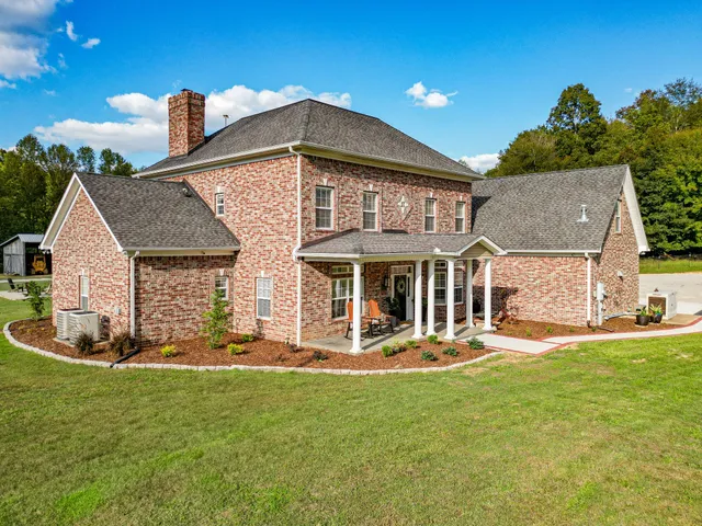a front view of house with yard and ocean